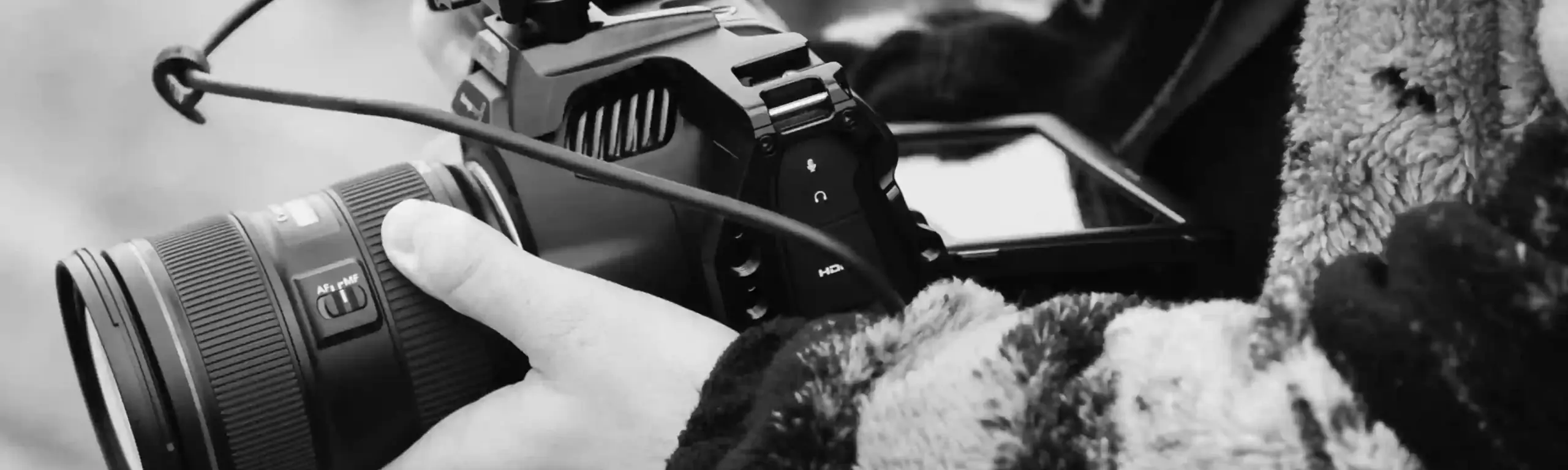 A black-and-white photograph of a camera operator. IGS Production also use it on their own home page.